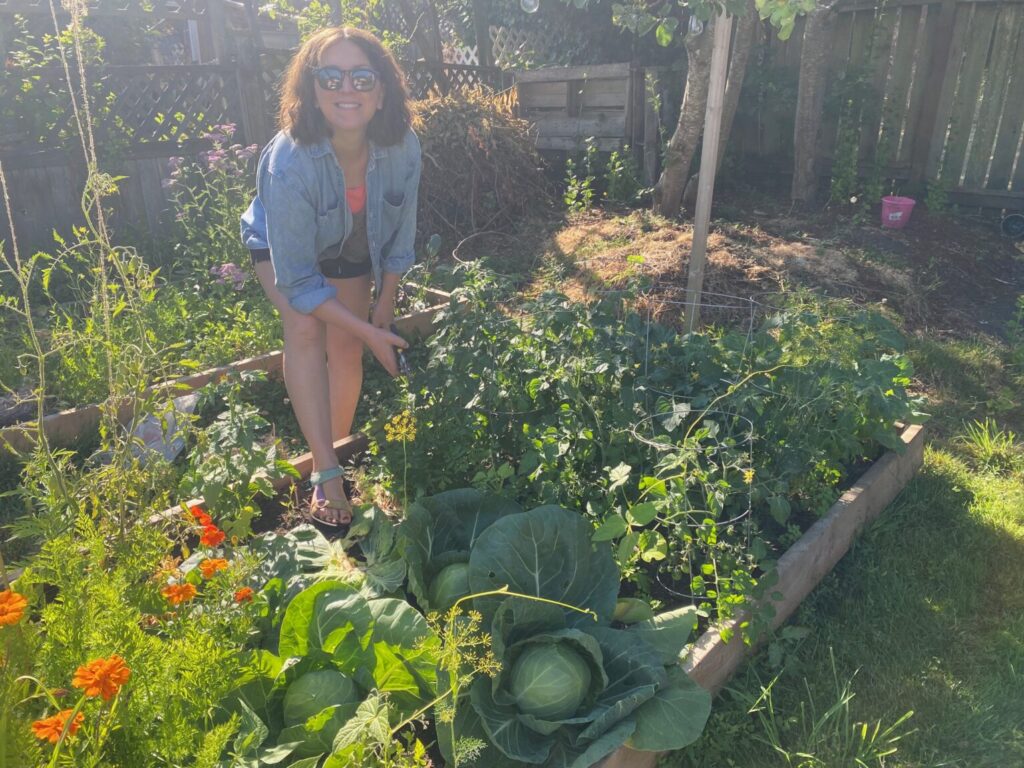 Jade in her garden, looking proud of all she's grown