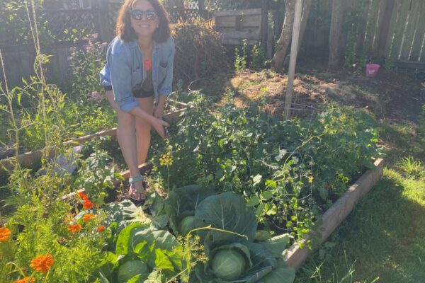 Jade in her garden, looking proud of all she's grown